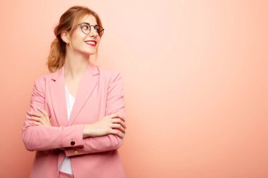 Genç, güzel sarışın kadın mutlu, gururlu ve umutlu merak ediyor ya da düşünüyor, çapraz kollarla uzayı taklit etmeye çalışıyor. iş kavramı