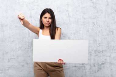 Genç ve güzel bir kadın grunge duvarına pankart asıyor.