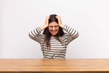 Genç, güzel bir kadın kendini stresli ve hayal kırıklığına uğramış hissediyor. Eli kolu bağlı, yorgun, mutsuz ve migreni olan bir masada oturuyor.