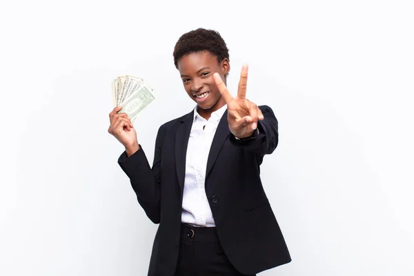 年轻漂亮的黑人妇女 面容快乐 无忧无虑 积极向上 用一只手拿着美元钞票表示胜利或和平 — 图库照片