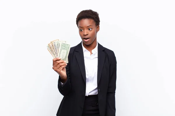 年轻漂亮的黑人女人看上去非常震惊或惊讶 张大嘴说 美元钞票 — 图库照片