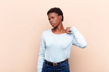Genç ve güzel siyah kadın stresli, endişeli, yorgun ve hayal kırıklığına uğramış, gömleğini çekiştirmiş, sorunlu görünüyor.