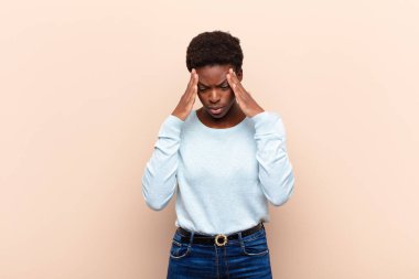 Genç ve güzel siyah kadın stresli ve hayal kırıklığına uğramış görünüyor. Baskı altında çalışıyor ve sorunlarla boğuşuyor.