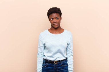 Genç, siyah kadın hissizliği, kafası karışık ve hangi seçeneği seçeceği belirsiz, sorunu çözmeye çalışıyor.