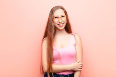 Genç sarışın kadın utangaç ve neşeli gülüyor, arkadaş canlısı ve olumlu ama güvensiz bir tavırla.