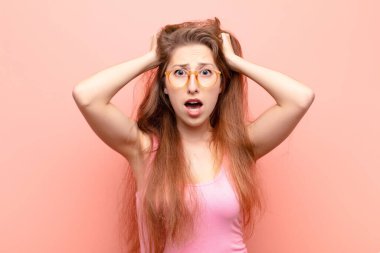 Genç sarışın kadın kendini stresli, endişeli, endişeli ya da korkmuş hissediyordu. Elleri başının üstünde, hatayla panikliyordu.