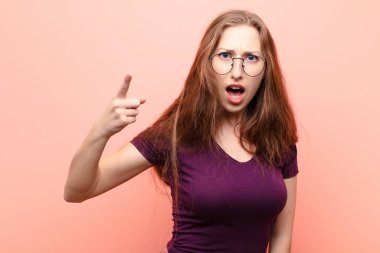 Genç sarışın kadın, kızgın agresif bir ifadeyle kameraya bakıyor. Öfkeli, çılgın bir patron gibi görünüyor.