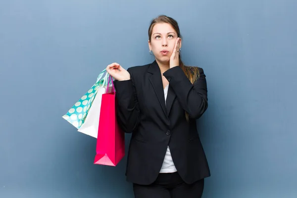 Jong Blond Vrouw Met Shopping Tassen Tegen Grunge Muur Achtergrond — Stockfoto