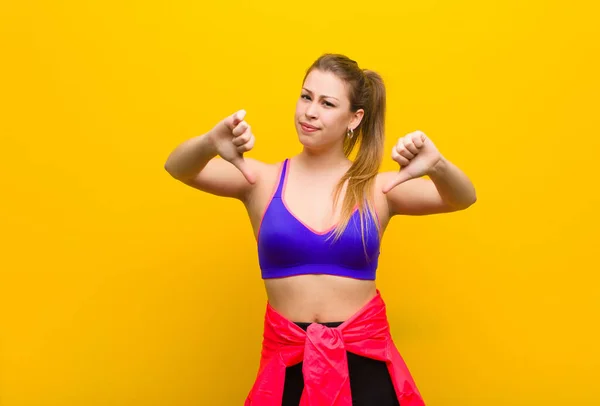 Jonge Blonde Vrouw Kijkt Verdrietig Teleurgesteld Boos Toont Duimen Naar — Stockfoto