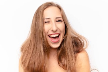 Genç ve güzel bir kadın mutlu ve arkadaş canlısı görünüyor, gülümsüyor ve sana olumlu bir tavırla göz kırpıyor.