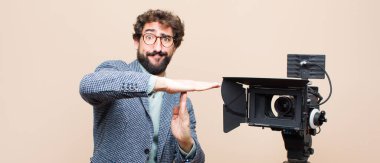 Televizyon sunucusu ciddi, sert, kızgın ve canı sıkkın görünüyor.