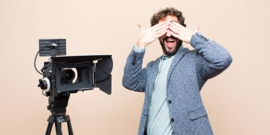 Televizyon sunucusu gülümsüyor ve mutlu hissediyor, iki eliyle gözlerini kapatıyor ve inanılmaz bir sürpriz bekliyor.