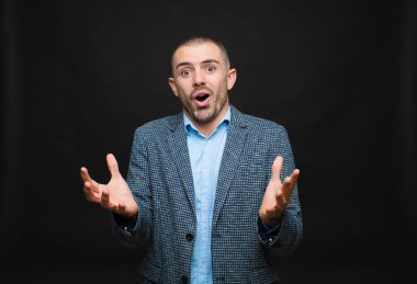 Genç işadamı ağzı açık ve şaşırmış, şok olmuş ve şaşırmış bir şekilde düz duvara karşı inanılmaz bir sürpriz yaptı.