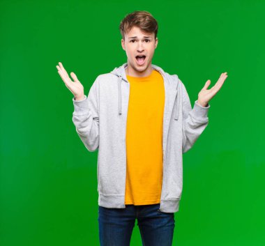 Genç sarışın adam mutlu, heyecanlı, şaşırmış ya da şaşırmış hissediyor, gülümsüyor ve şaşırıyor.