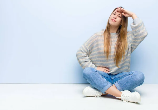 金发碧眼的年轻女子在向摄像机致意时 带着军人的敬意和爱国心 恭恭敬敬地坐在地板上 — 图库照片