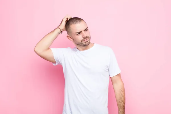 Jovem Homem Bonito Sentindo Perplexo Confuso Coçando Cabeça Olhando Para — Fotografia de Stock