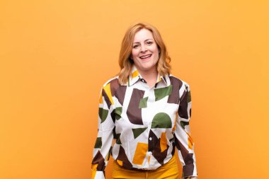 Büyük, dostane, kaygısız bir gülümsemesi olan orta yaşlı bir kadın. Olumlu, rahat ve mutlu görünüyor.