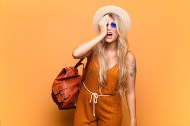 Genç ve güzel Latin bir kadın uykulu, sıkılmış ve esniyor, baş ağrısı ve yüzünün yarısını kaplayan bir eliyle. turizm konsepti