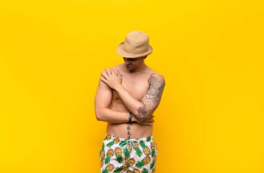 Genç ve yakışıklı bir adam endişeli, hasta, hasta ve mutsuz hissediyor. Ağrılı bir mide ağrısı ya da grip geçiriyor.