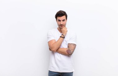 Genç yakışıklı adam gülümsüyor, hayattan zevk alıyor, mutlu, arkadaş canlısı, tatmin olmuş ve tasasız.