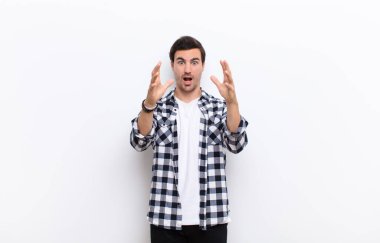 Genç yakışıklı adam ellerini havaya kaldırarak bağırıyor. Öfkeli, sinirli, stresli ve üzgün hissediyor.