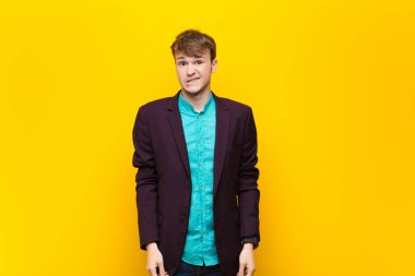 Genç sarışın adam şaşkın ve şaşkın görünüyor. Sinirli bir hareketle dudağını ısırıyor. Sorunun cevabını bilmiyor.