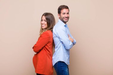 Genç ve güzel bir çift bej düz duvara karşı