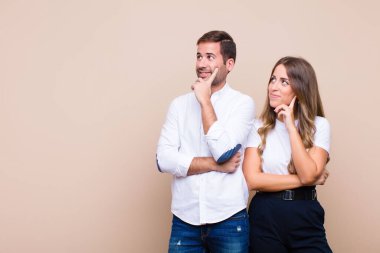 Genç ve güzel bir çift bej düz duvara karşı