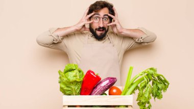 Yeşil bakkal adam ellerini kaldırıyor, ağzı açık, son derece şanslı, şaşırmış, heyecanlı ve mutlu hissediyor.