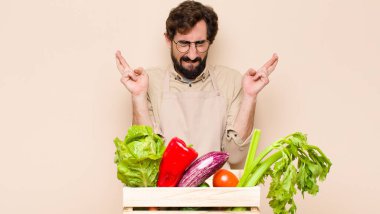 Yeşil bakkal adam gülümsüyor ve endişeyle iki parmağını çapraz yapıyor. Endişeli ve iyi şanslar diliyor.