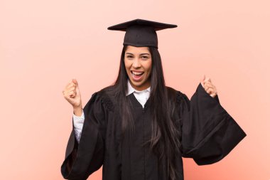 Genç Latin kız öğrenci mutlu, pozitif ve başarılı hissediyor, zaferi, başarıları veya iyi şansı kutluyor.