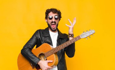 Genç müzisyen öfkeyle bağırıyor, stres altında ve elleri havada neden benim gitar, rock and roll konseptimle...