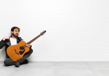 Genç müzisyen kendini stresli, endişeli, yorgun ve hayal kırıklığına uğramış hissediyor. Boynunu çekiştiriyor. Gitar, rock 'n roll konseptiyle ilgili sorunları olan birine benziyor.