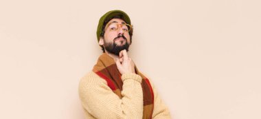 Genç havalı sakallı adam ciddi görünüyor, kafası karışık, kararsız ve düşünceli, seçenekler ve seçimler arasında şüpheci.