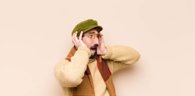 Genç havalı sakallı adam el ele tutuşuyor, ağzı açık, son derece şanslı, şaşırmış, heyecanlı ve mutlu hissediyor.