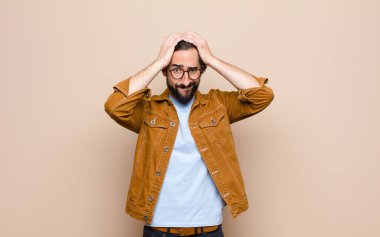 Genç, havalı ve çılgın adam yassı duvara yaslanmış.