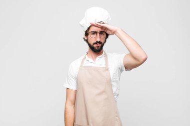 Genç çılgın aşçı, beyaz duvara karşı saygı göstererek, onur ve vatanseverlik eylemiyle kamerayı selamlıyor.