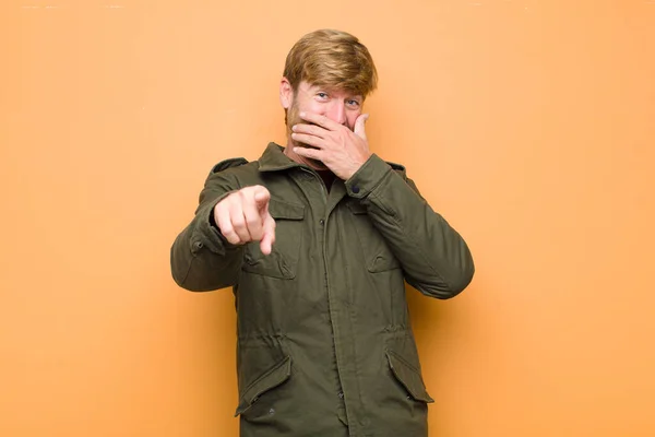 Joven Hombre Rubio Riéndose Apuntando Cámara Burlándose Burlándose Contra Pared — Foto de Stock