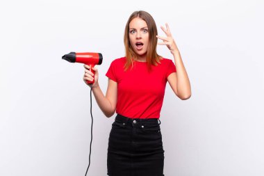 Kızıl saçlı, güzel bir kadın ellerini havaya kaldırıp bağırıyor. Öfkeli, hayal kırıklığına uğramış, stresli ve üzgün bir şekilde kuaförü tutuyor.