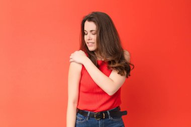 Genç, güzel bir kadın endişeli, hasta, hasta ve mutsuz hissediyor. Ağrılı bir mide ağrısı ya da kırmızı duvarda grip geçiriyor.