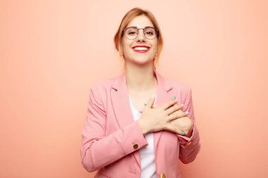 Genç, güzel sarışın kadın romantik, mutlu ve aşık, neşeyle gülümseyen ve kalbe yakın el ele tutuşan. iş kavramı