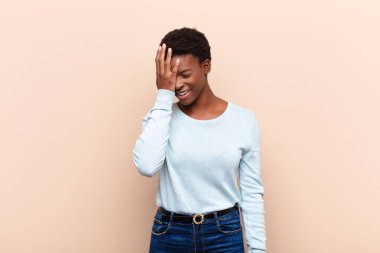 Genç ve güzel siyahi kadın gülüyor ve alnına şaplak atıyor. Unuttum ya da aptalca bir hataydı. 