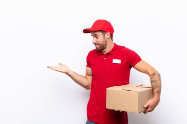 Neşeli bir şekilde gülümseyen ve bir objeyi gösteren veya reklamını yapan avucundaki kopyalama alanını işaret eden. dağıtım konsepti