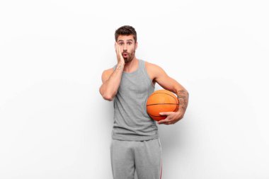 Genç yakışıklı adam şok olmuş ve şaşkınlık içinde. Elinde basketbol topu ağzında açık bir şekilde inanmayarak el ele tutuşuyor..