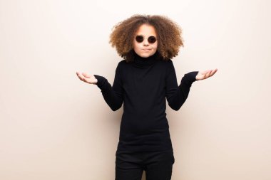 Afrikalı Amerikalı küçük kız düz duvara yaslanmış. cool konsept