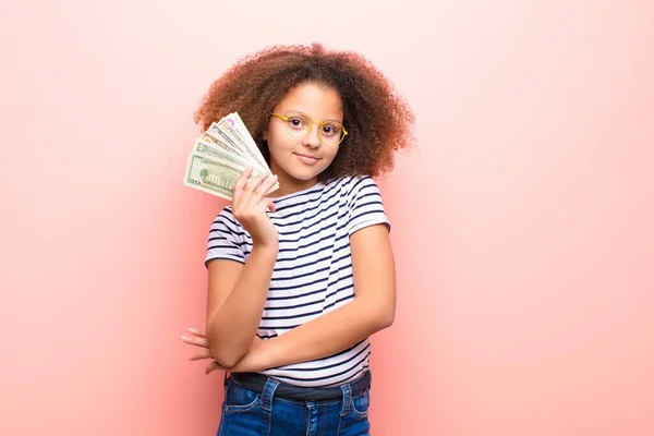 非洲裔美国小女孩靠在平板墙上 手里拿着美元钞票 — 图库照片