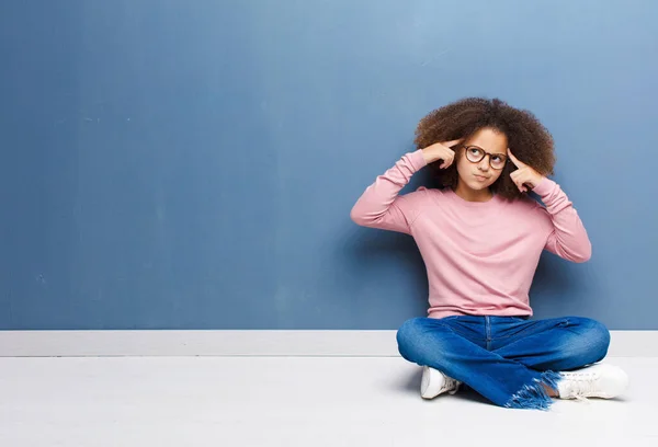アフリカ系アメリカ人の少女は床に座っている課題や問題の解決策を想像しながら — ストック写真