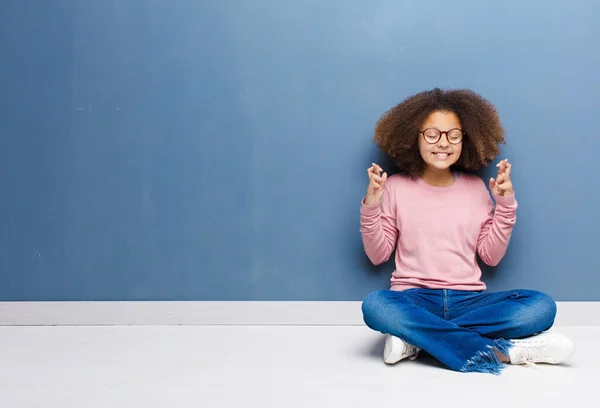 アフリカ系アメリカ人の少女は緊張して希望を感じ 指を交差させ 床に座って幸運を願っています — ストック写真