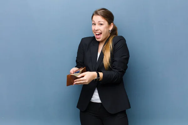 Jong Blond Vrouw Met Een Portemonnee Tegen Grunge Muur Achtergrond — Stockfoto