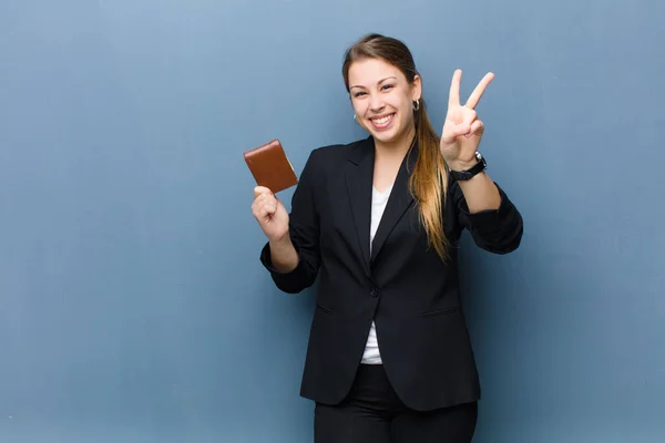 young blonde woman with a wallet against grunge wall background